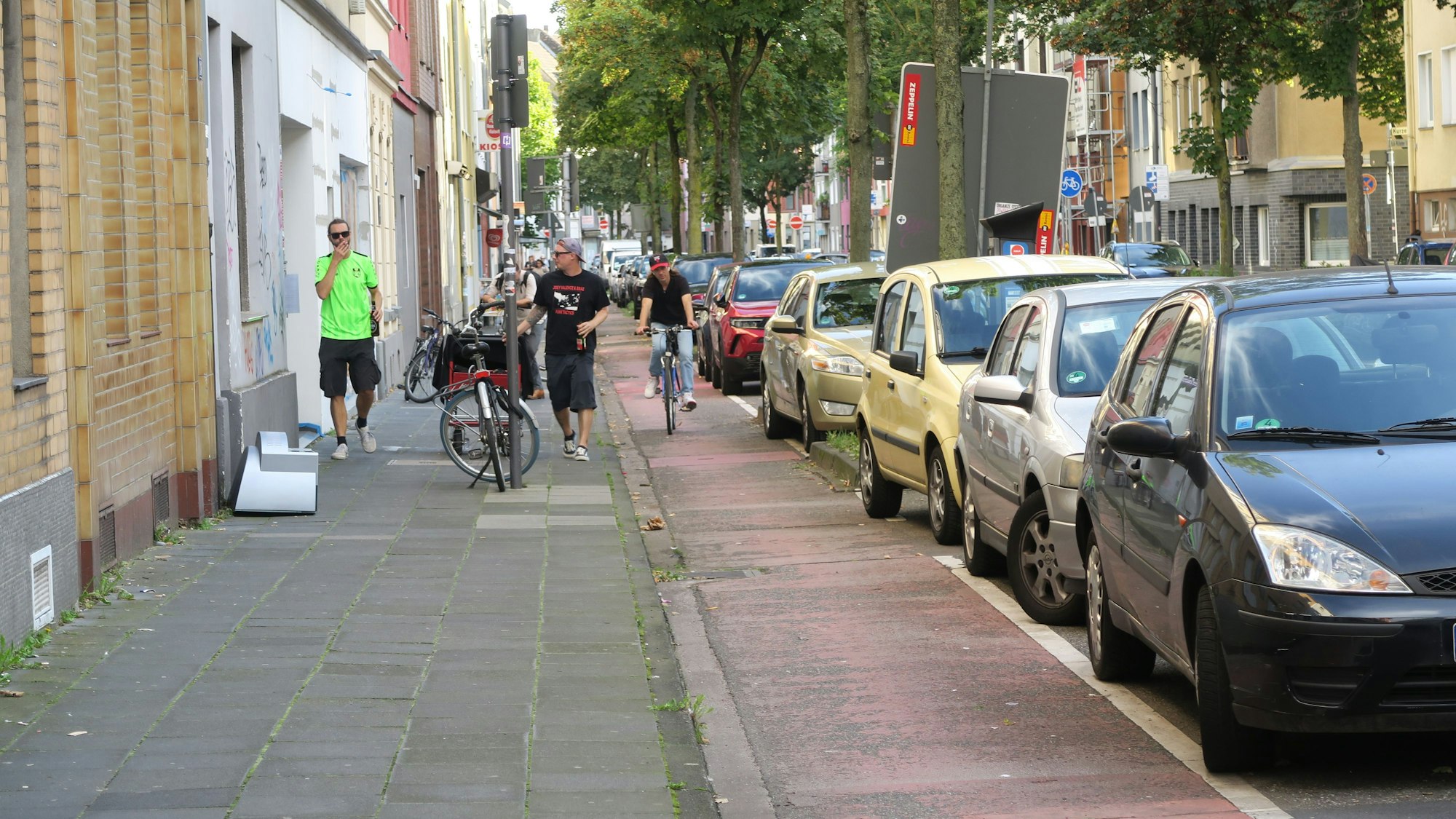 Ein Radfahrer nutzt den Radweg auf der Kalk-Mülheimer-Straße zwischen Bürgersteig und parkenden Autos.