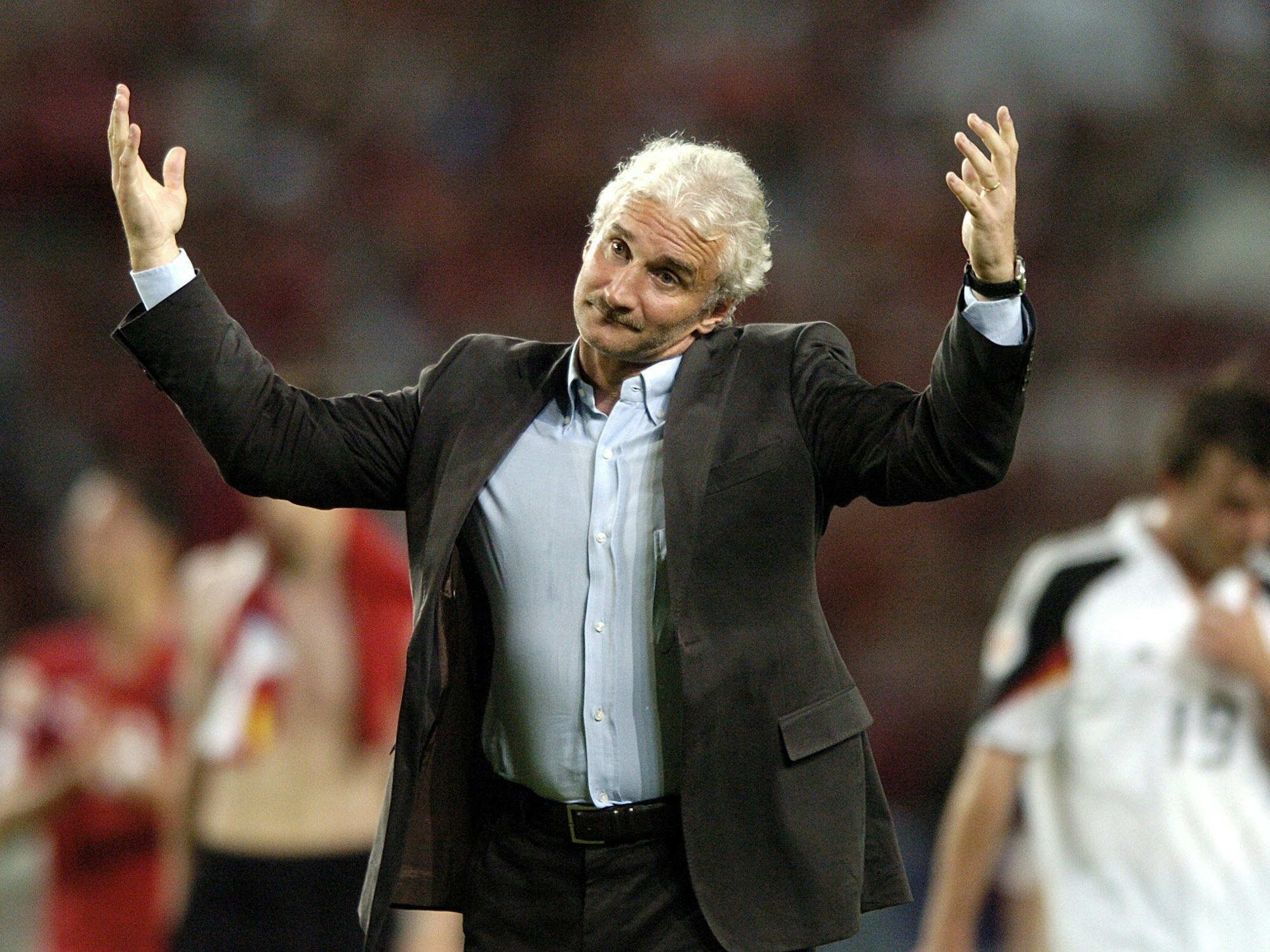 DFB-Teamchef Rudi Völler zuckt mit den Schultern während er sich bei den deutschen Fans für die Unterstützung bedankt.