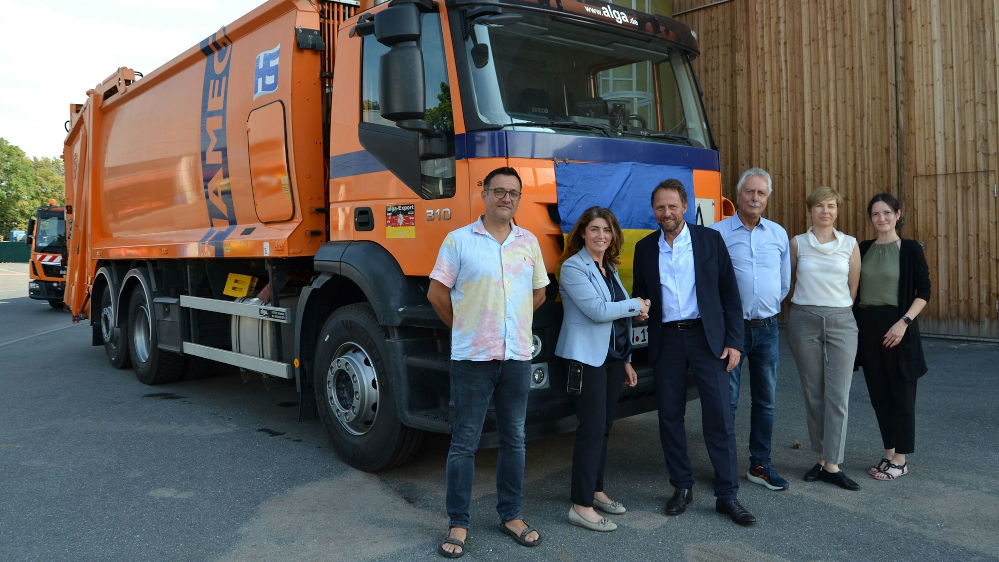 Oberbürgermeister Uwe Richrath übergibt Linda Mai vom Verein Blau-Gelbes Kreuz ein Müllfahrzeug.