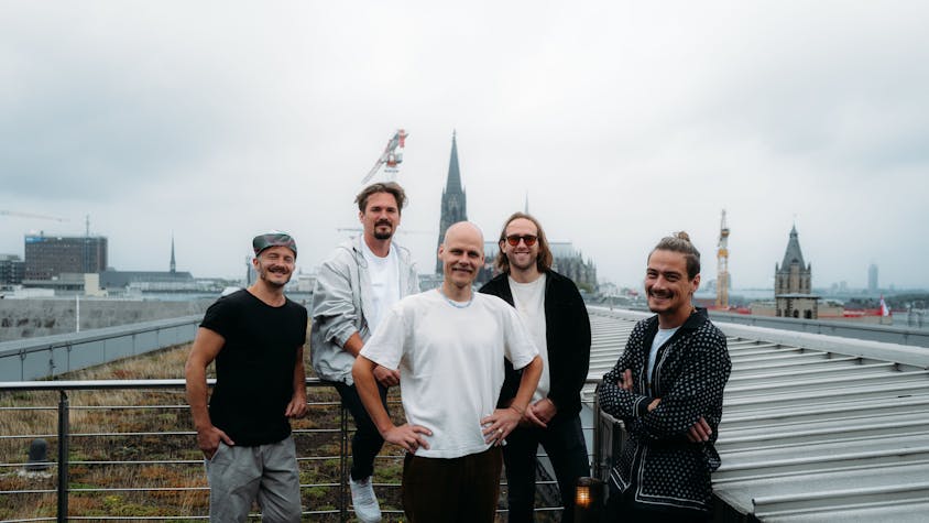 Die fünf Bandmitglieder von Cat Ballou stehen auf einem Dach, im Hintergrund der Kölner Dom.&nbsp;