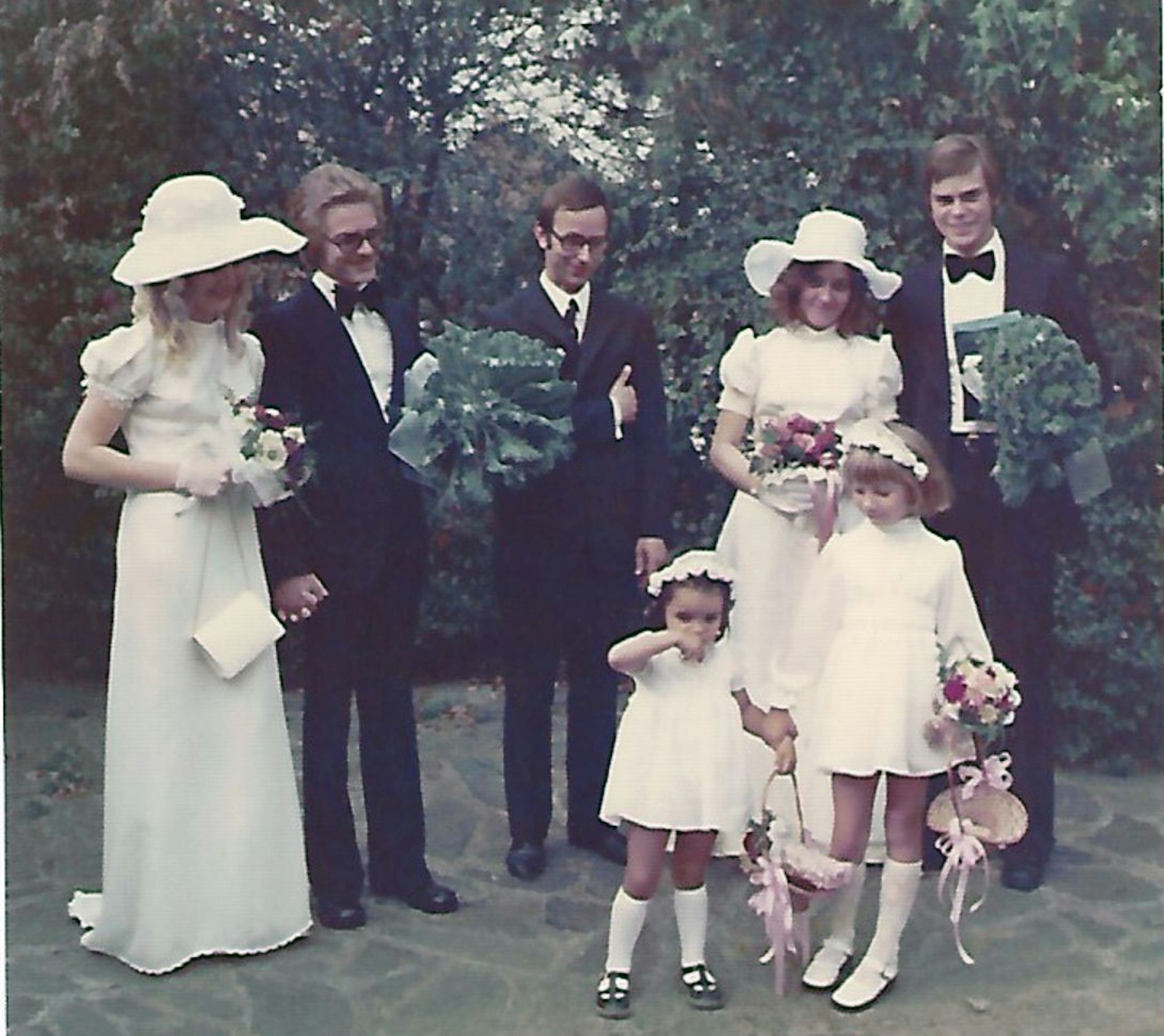 Ein altes Hochzeitsfoto mit zwei Frauen, drei Männern und zwei Kindern.