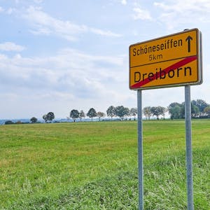Das Bild zeigt das Schild am Ortsausgang von Dreiborn mit dem Hinweis, dass es fünf Kilometer bis zum Nachbarort Schöneseiffen sind.