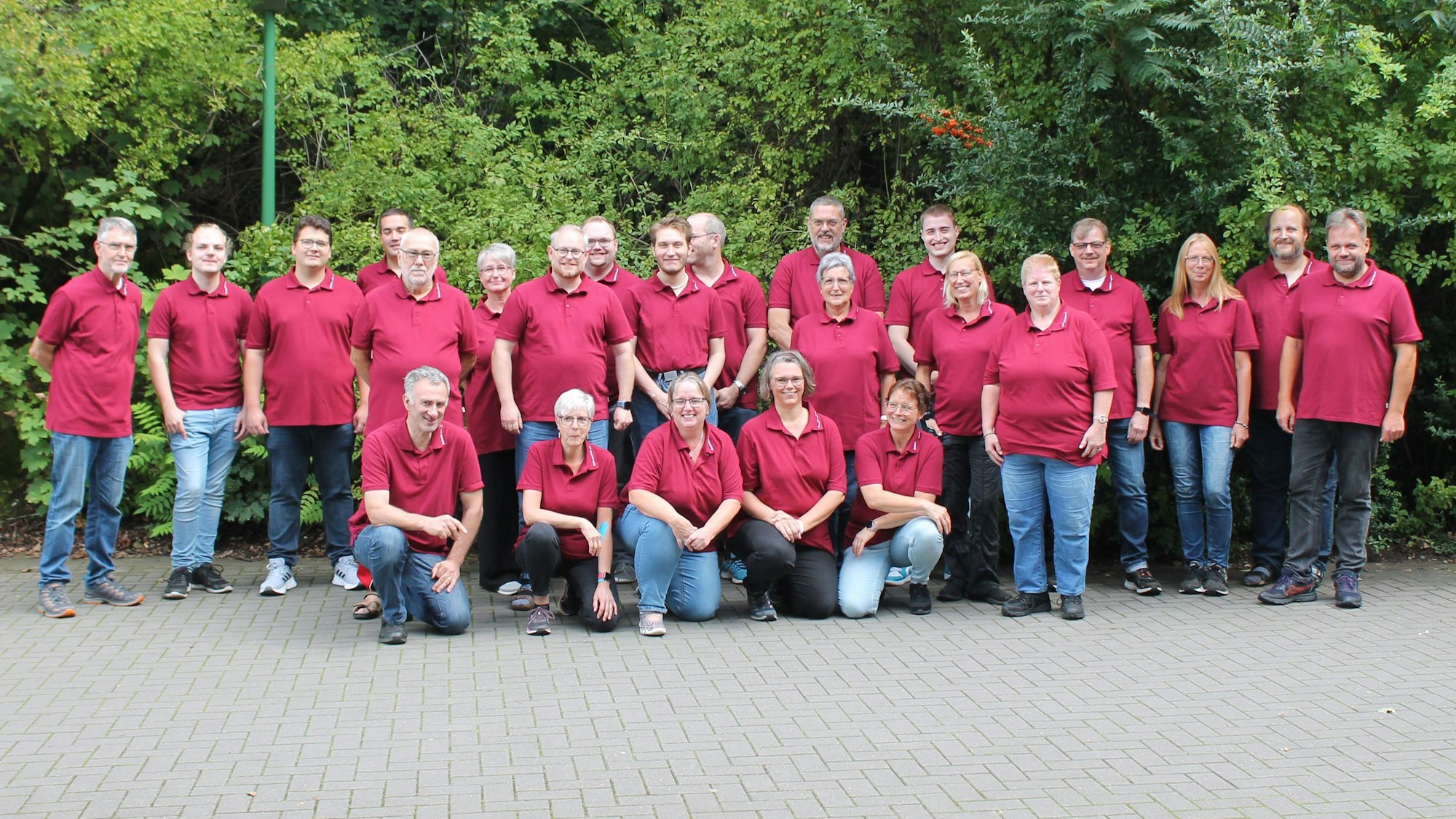 Rund 20 Mitglieder des Musikvereins Loope posieren in roten Polohemden.