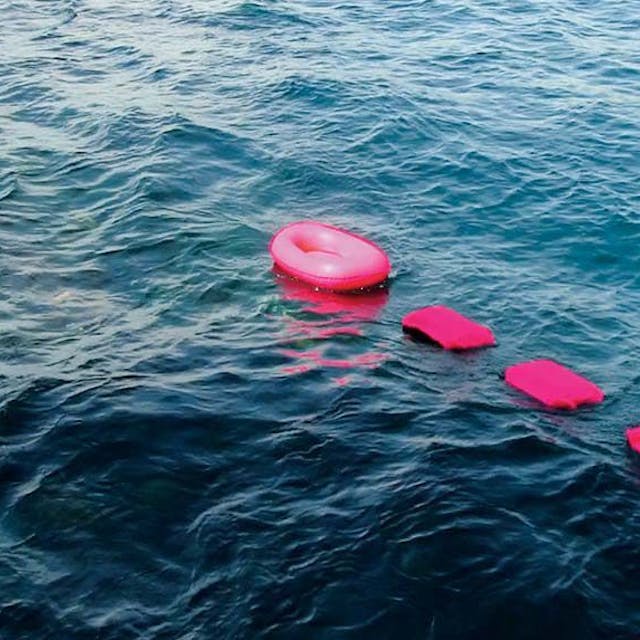 Vier rosa Boote schaukeln auf den Wellen.
