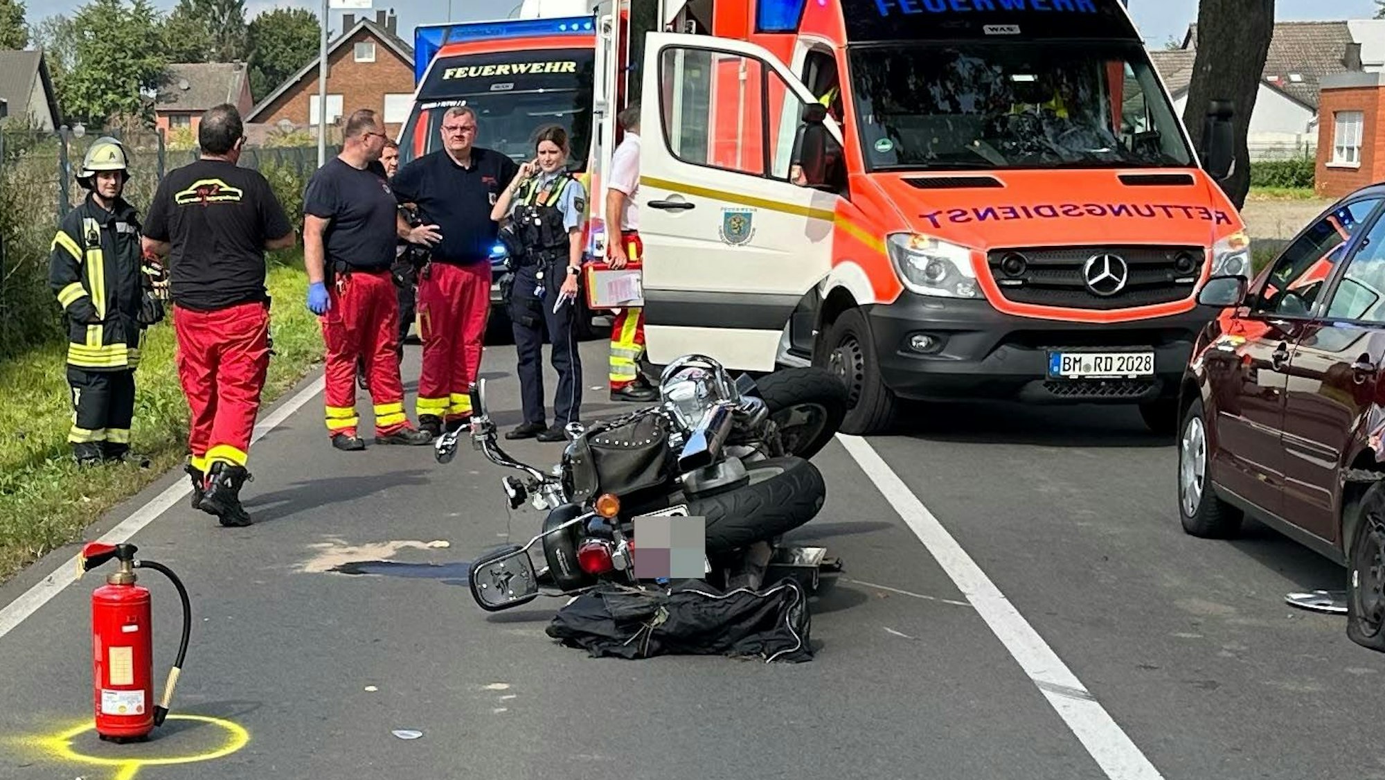 Das Bild zeigt ein Motorrad und mehrere Rettungskräfte.