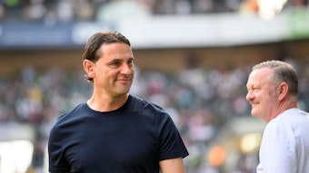 Roland Virkus (r.) lächelt Gerardo Seoane, Trainer von Borussia Mönchengladbach, an.