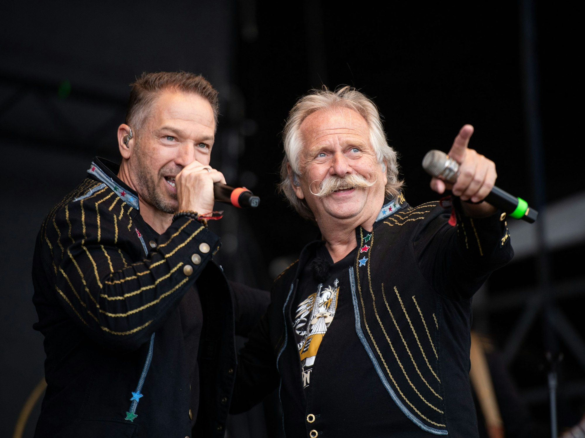 Henning Krautmacher (r) und Patrick Lück, Sänger der Band Höhner, stehen beim Wacken Open Air Festival auf der Bühne.