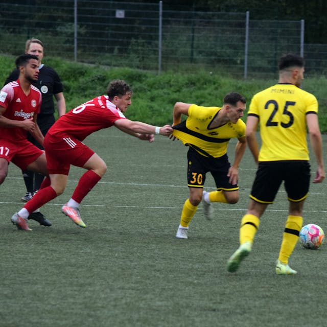 Bergisch Gladbachs Fußballer Nico Kuhbier zieht am Trikot des Hohkeppelers Ansgar Pflüger, um diesen vom Ball fernzuhalten.