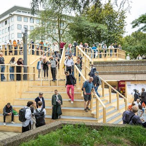 Menschen stehen auf der neuen Holztreppe am Ebertplatz.&nbsp;