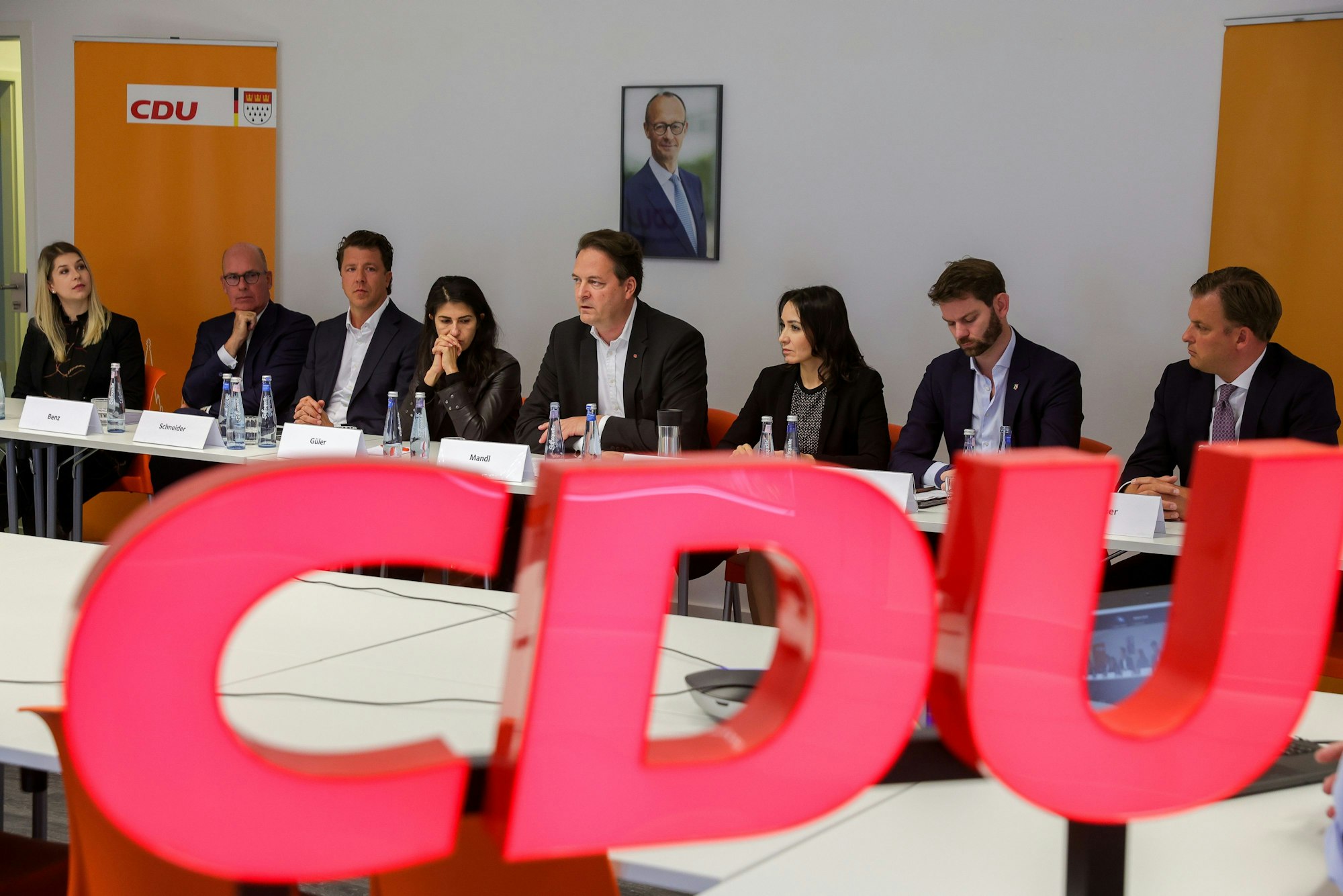 Der Vorstand der Kölner CDU sitzt hinter dem Parteilogo an einem Tisch.