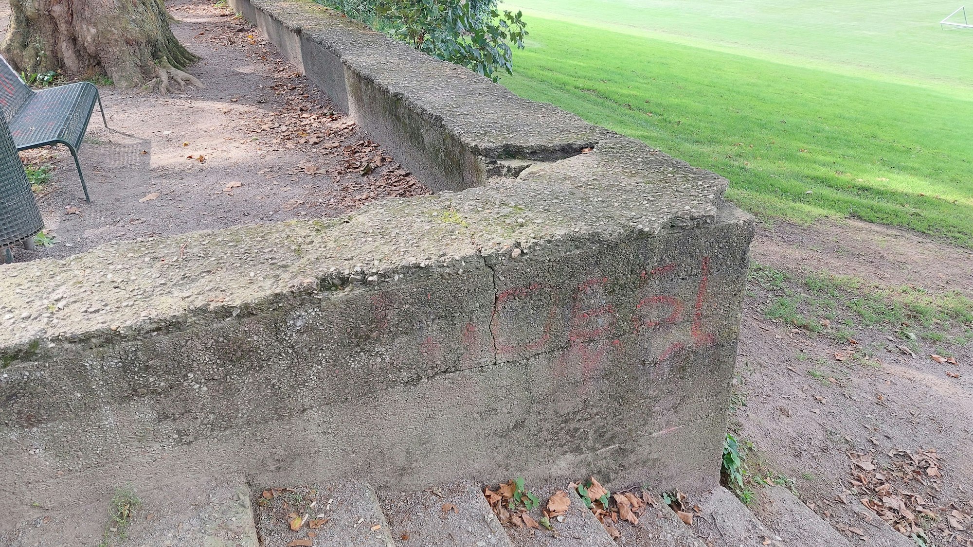 Die Mauer am Denkmal am Rande der Jahnwiesen hat Löcher.