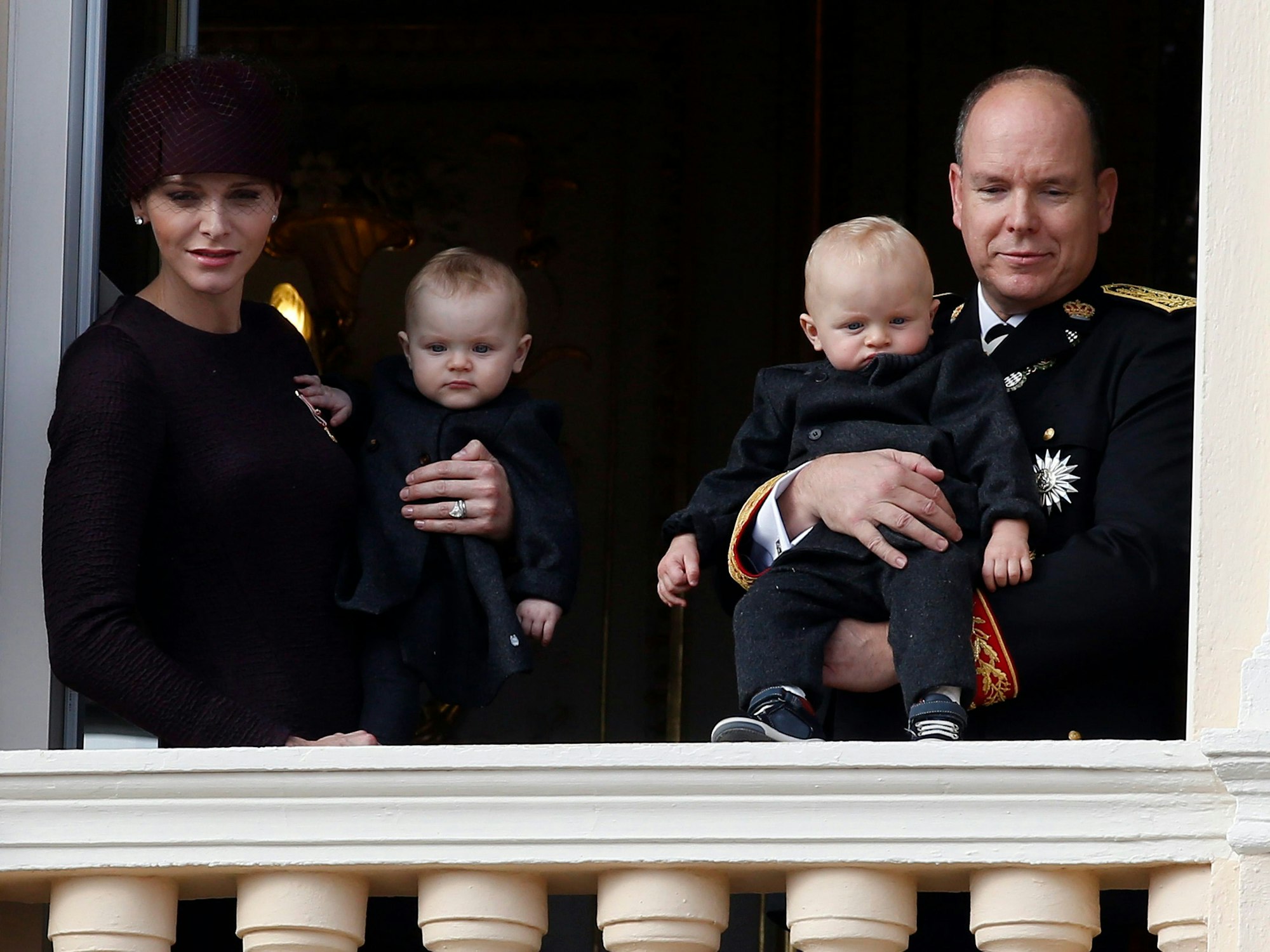Fürst Albert II und Charlene (L) halten ihre Kinder.