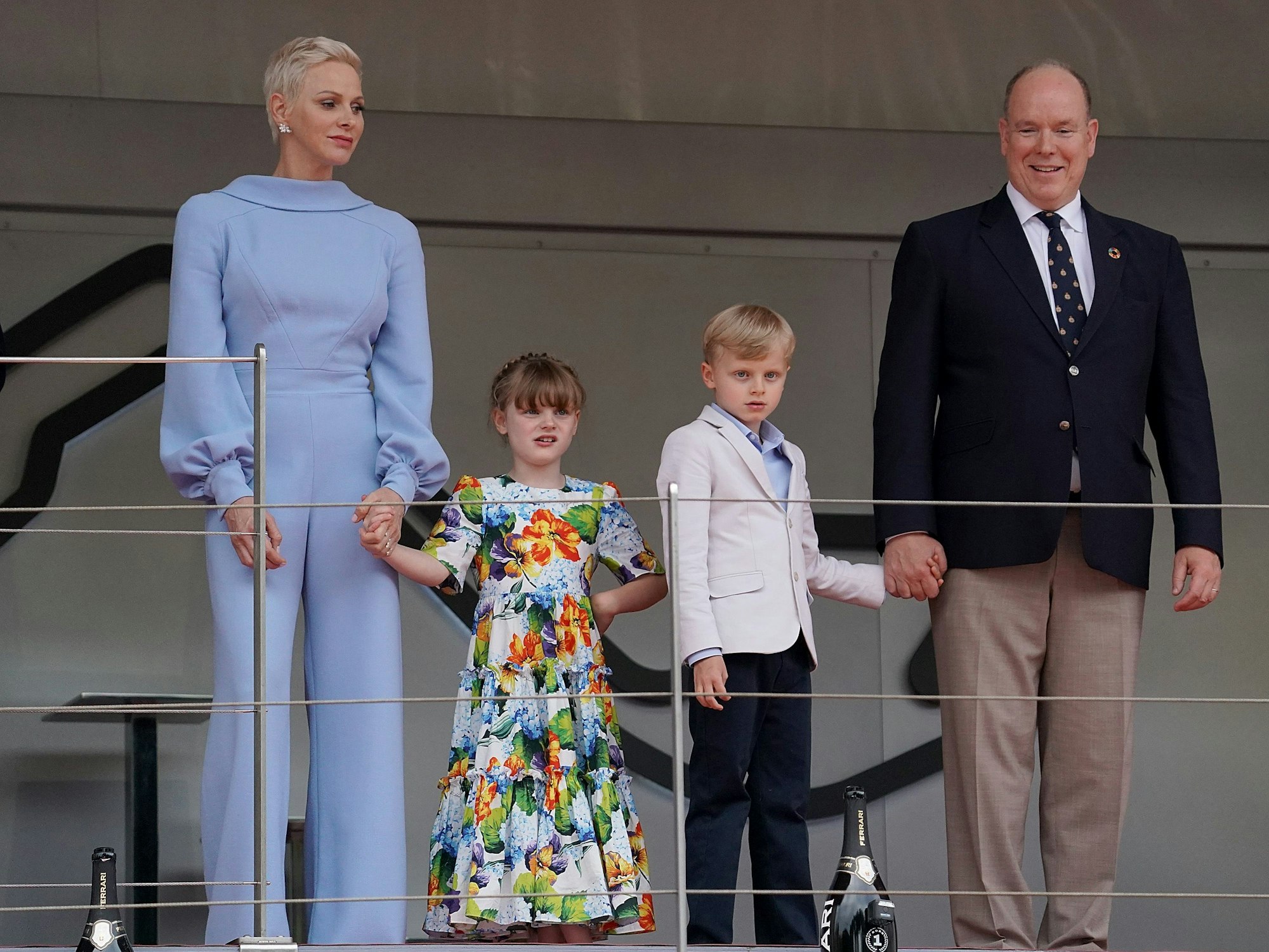 Fürstin Charlene, Prinzessin Gabriella und Prinz Jacques, und Fürst Albert II. von Monaco stehen auf einem Podium.