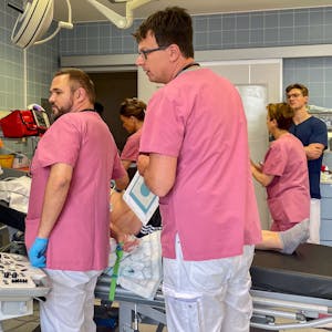 Mehrere medizinische Mitarbeiter in der Notaufnahme des Euskirchener Marienhospitals bei ihrer Arbeit. Ein Patient (verdeckt) liegt auf dem Behandlungstisch.