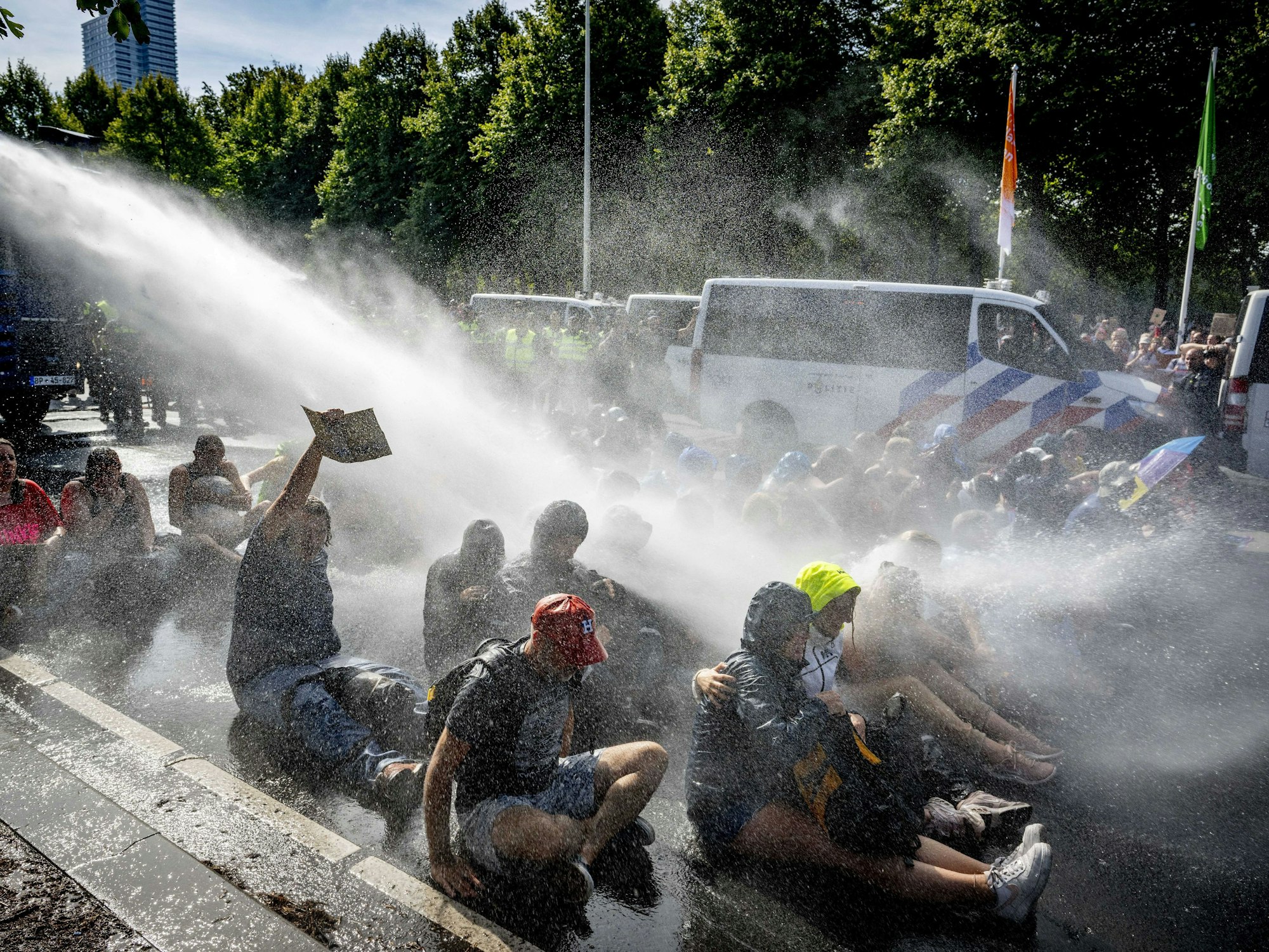 Die Polizei setzt Wasserwerfer gegen Klimaaktivistinnen und Klimaaktivisten ein, die auf der Fahrbahn der A12 demonstrieren.