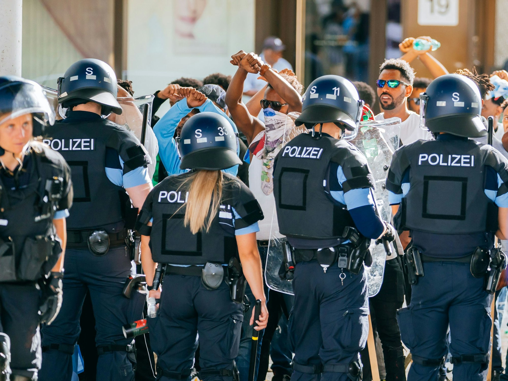 Eine Gruppe von Menschen wird nach Ausschreitungen bei einer Eritrea-Veranstaltung am Samstag von Polizeikräften eingekesselt.