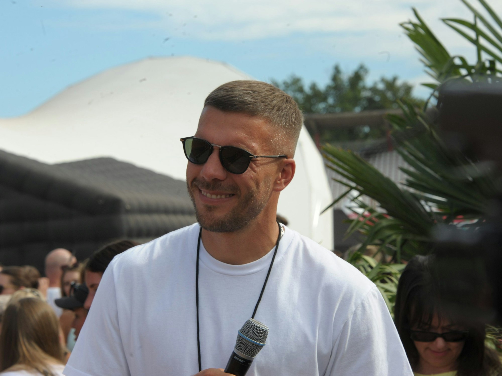 Mitorganisator Lukas Podolski lächelt am Samstag auf dem Glücksgefühle-Festival am Hockenheimring.
