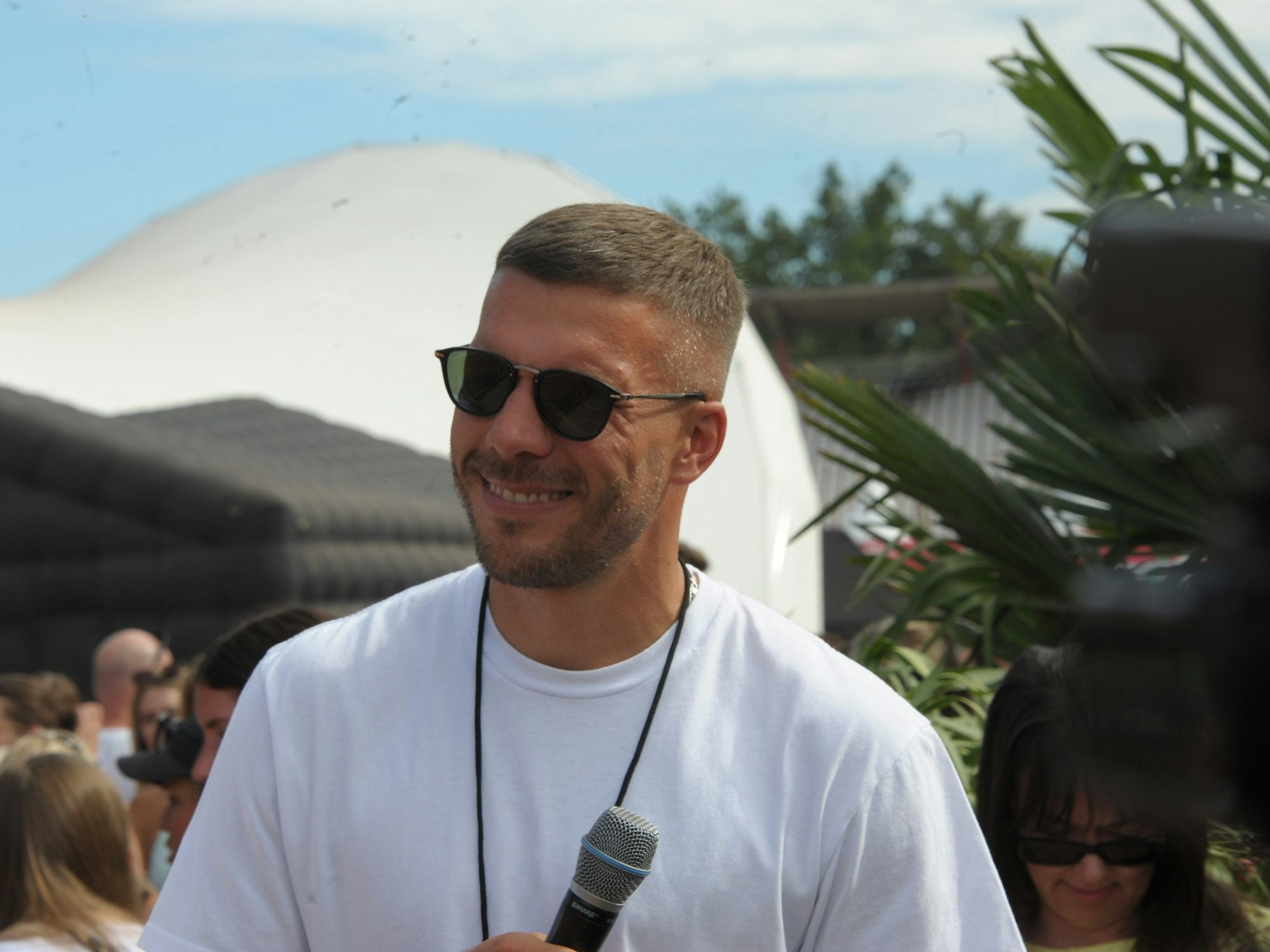 Mitorganisator Lukas Podolski lächelt auf dem Glücksgefühle-Festival.