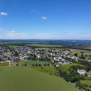 Eine Luftaufnahme zeigt das Dorf Dreiborn. Drumherum sind grüne Wiesen und Felder zu sehen.