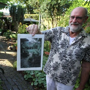 Bergische Gartentour 2023, offene Gärten, Michael Panthen in Lohmar-Neuhonrath hält ein Foto von seinem Garten vor der Umgestaltung in die Kamera&nbsp;
