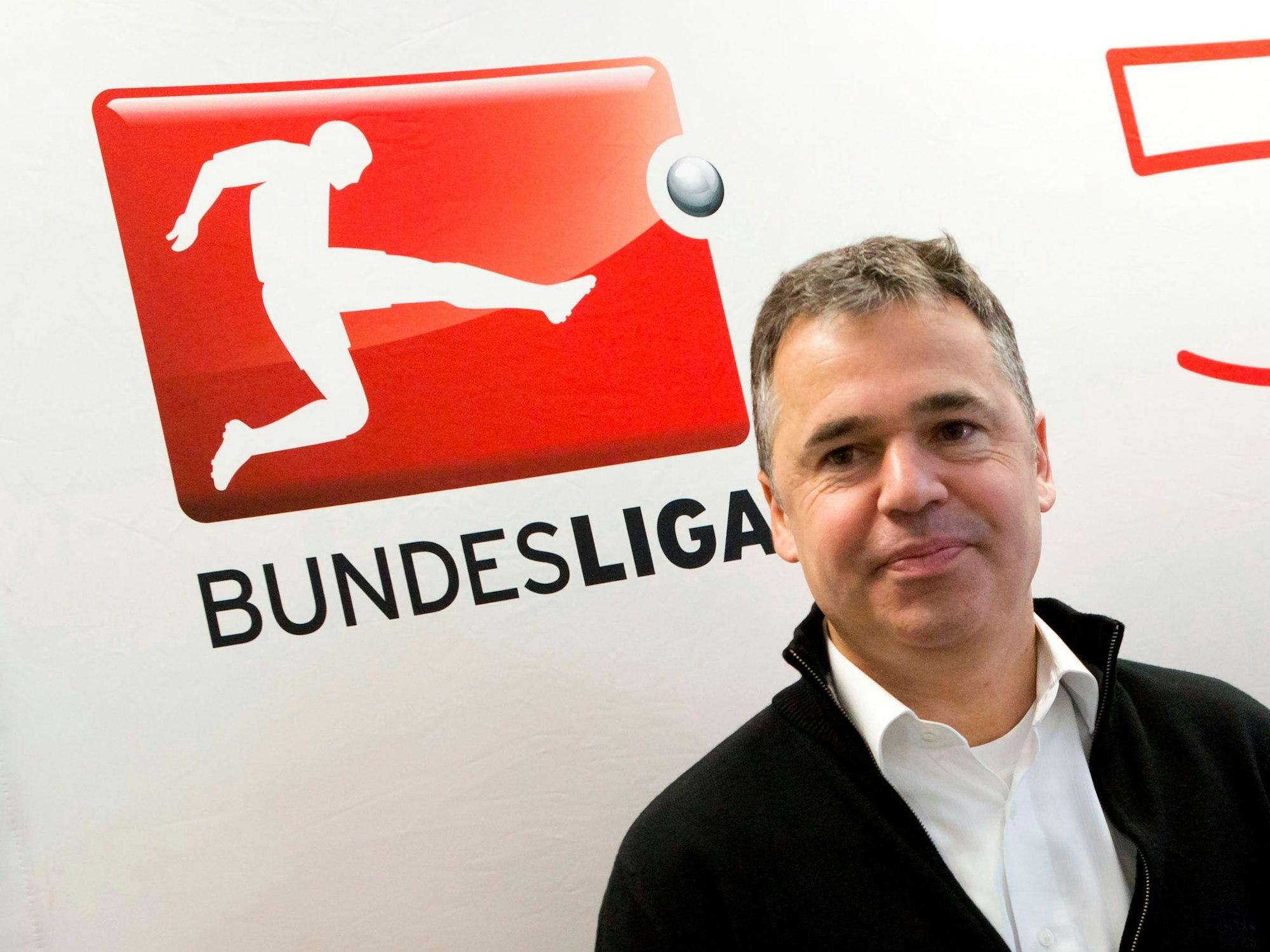 Andreas Rettig posiert vor dem DFL-Logo.