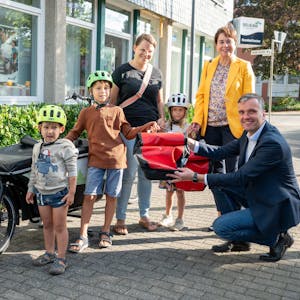 Elke Reichert und Marc Baack übergeben das Lastenrad an Familie Hutter.