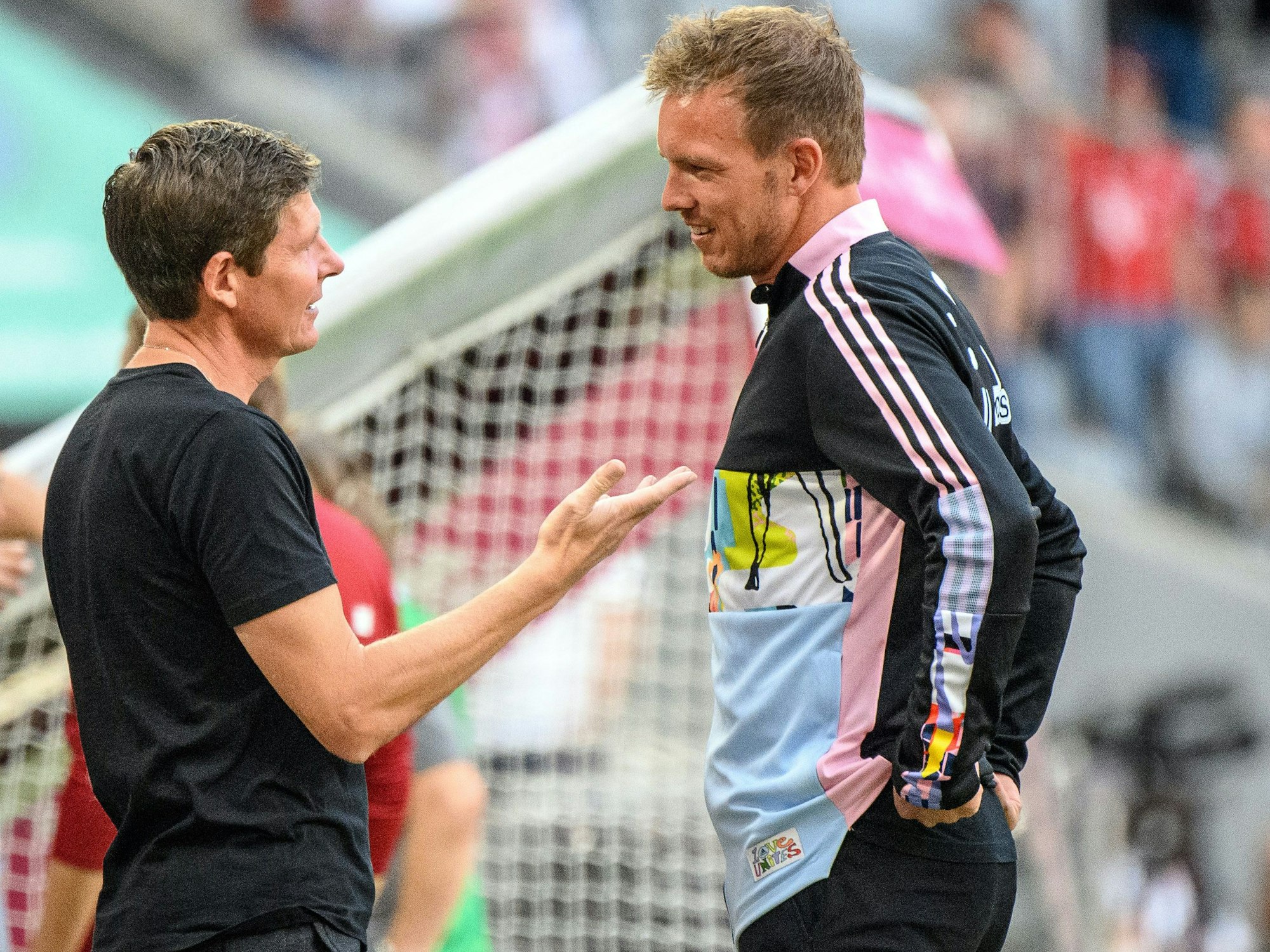 Frankfurts Cheftrainer Oliver Glasner (l) und Münchens Cheftrainer Julian Nagelsmann unterhalten sich vor Spielbeginn.