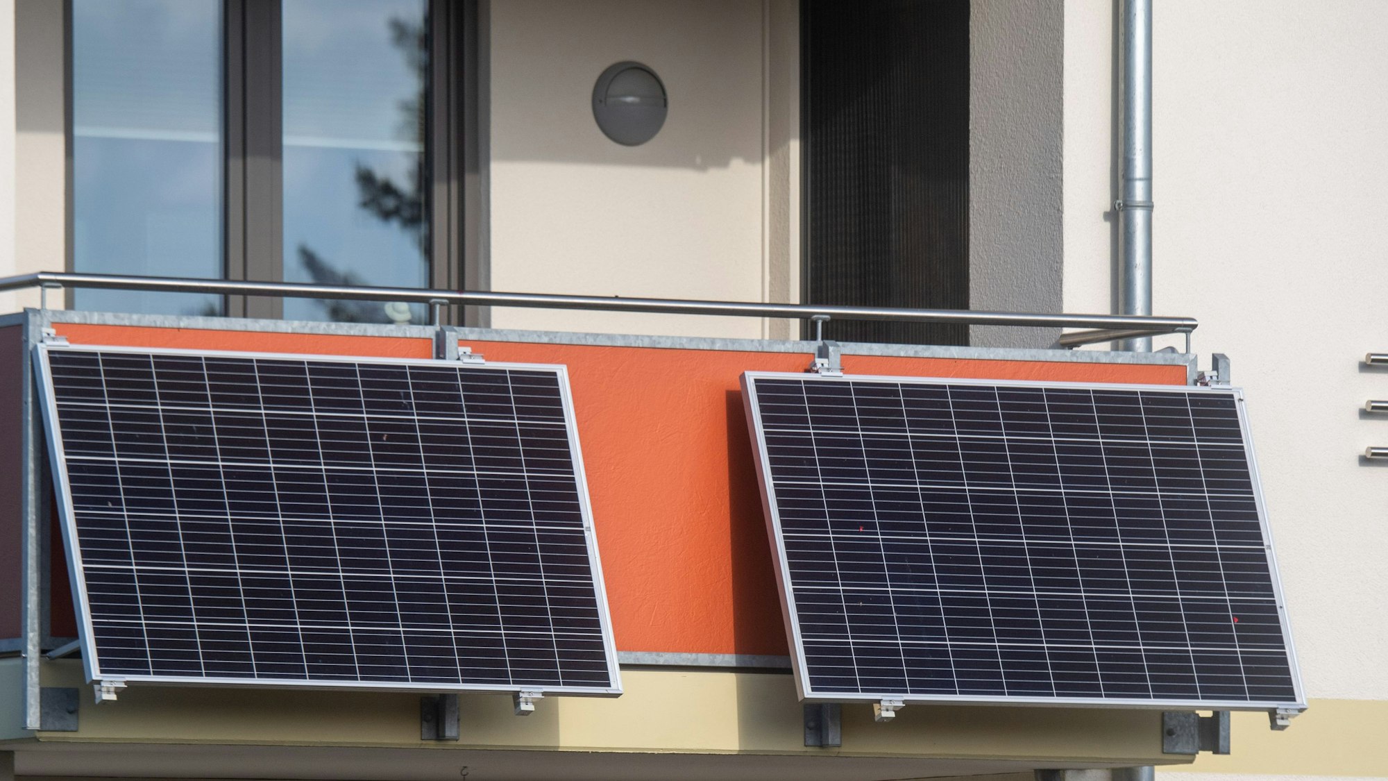 Das Foto zeigt zwei Solarmodule an einem Balkon.