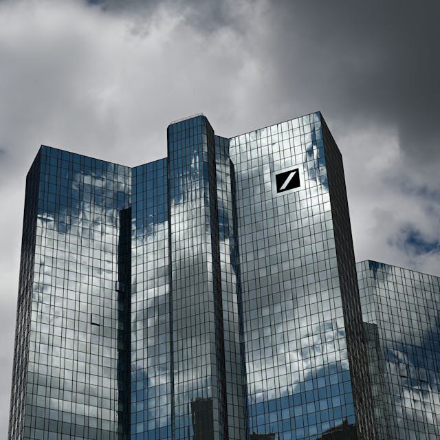 Hessen, Frankfurt/Main: Wolken ziehen über die Zentrale der Deutschen Bank, während sich der Wolkenhimmel in der Fassade spiegelt. (Symbolbild/Archivbild)