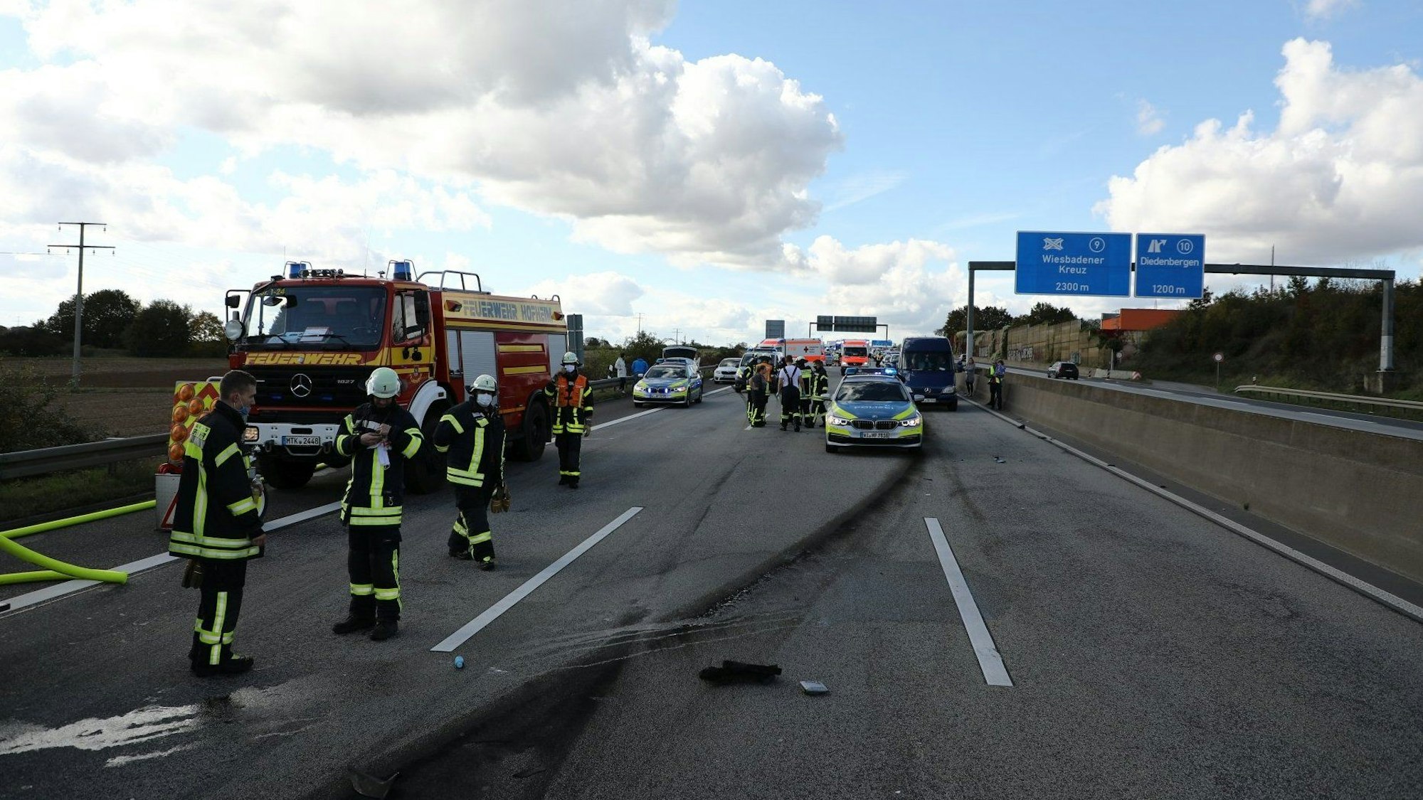 Polizei und Feuerwehr an einer Unfallstelle auf der Autobahn.