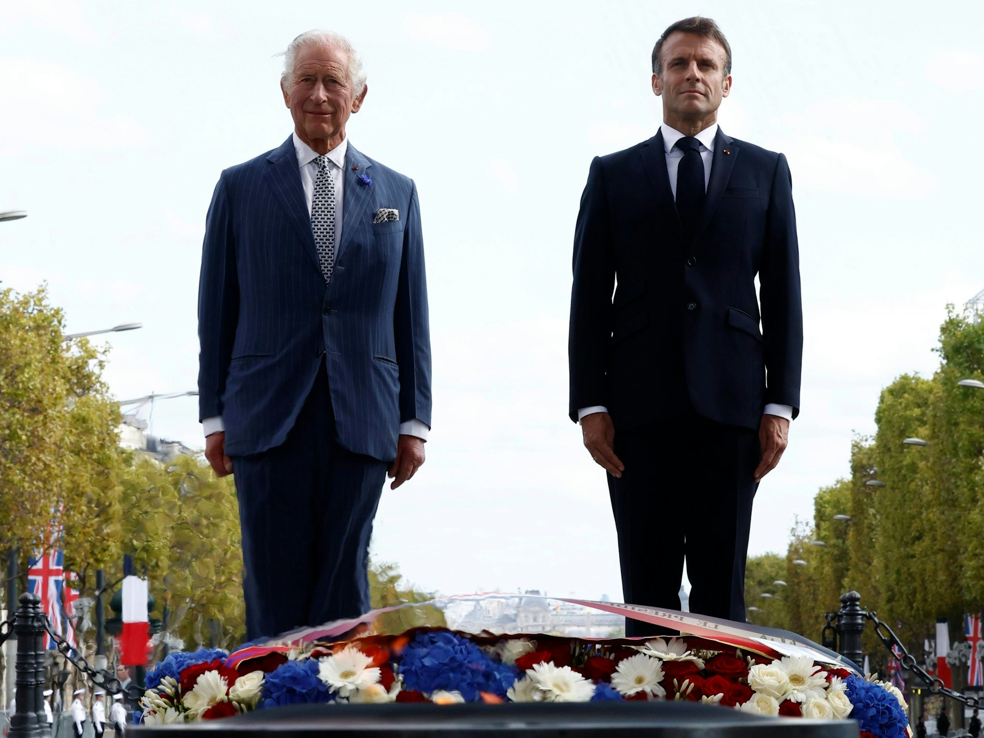 König Charles III. (l) von Großbritannien und Emmanuel Macron, Präsident von Frankreich, bei der feierlichen Begrüßung am Arc de Triomphe zu Beginn des Staatsbesuchs.