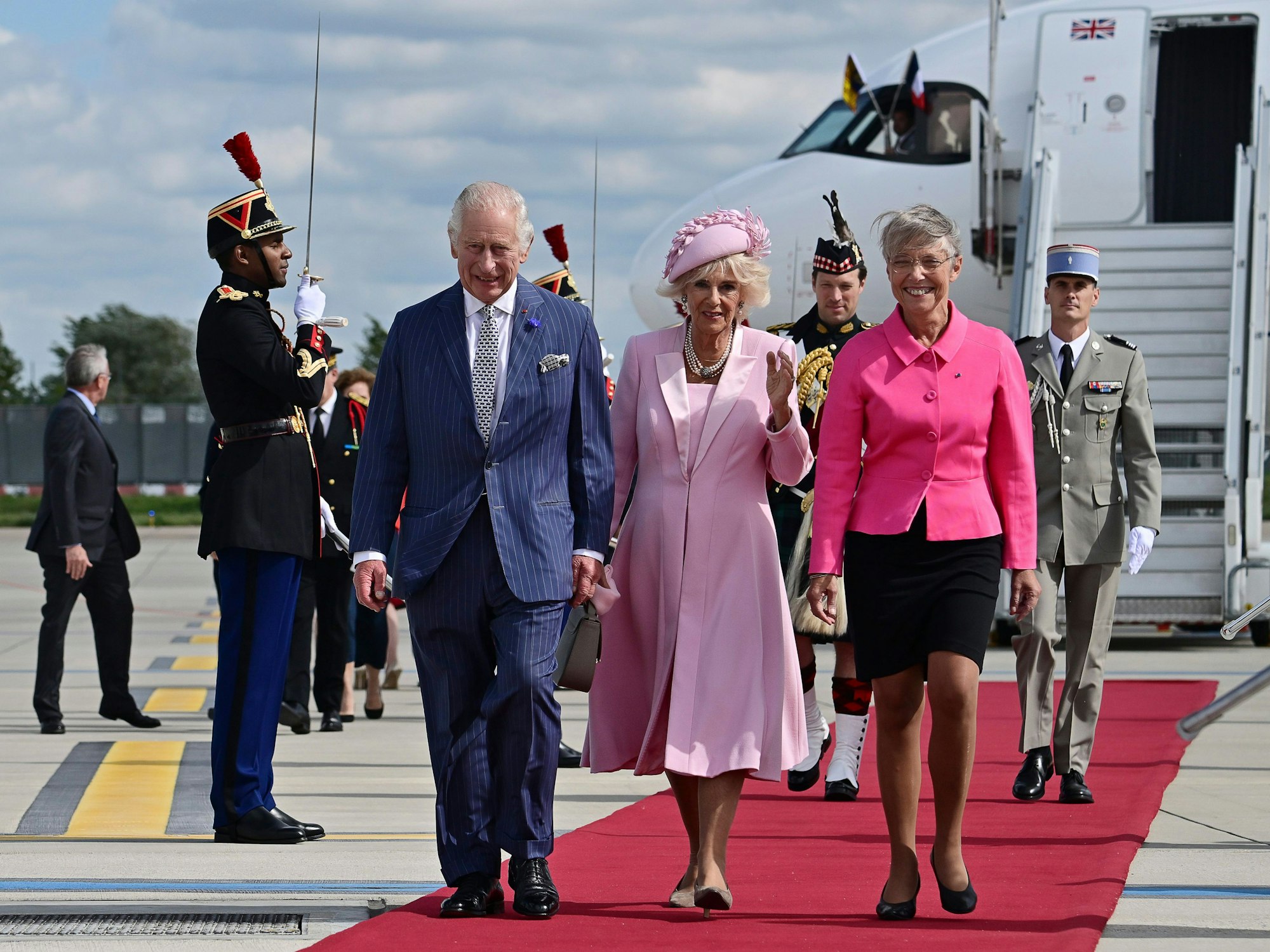 König Charles III. (l) und seine Gemahlin Camilla treffen Frankreichs Staatschef Emmanuel Macron. Im Bild werden sie von der französischen Premierministerin Elisabeth Borne begrüßt.