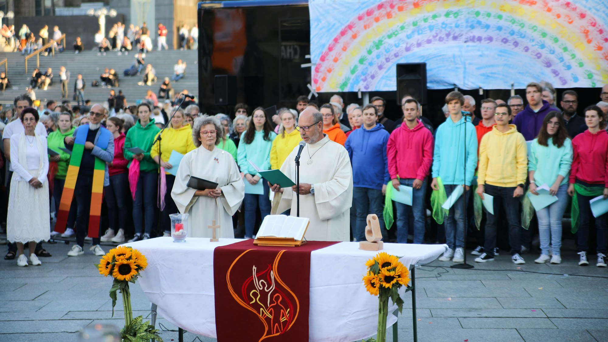 Pastoralreferent Manfred Becker-Irrnen während seiner Predigt beim Gottesdienst "Segen für alle" am Kölner Dom. Im Hintergrund der Jugendchors St. Stephan.