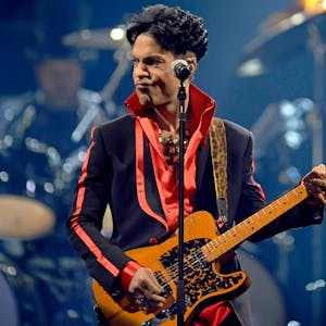 Prince spielt auf der Bühne Gitarre.