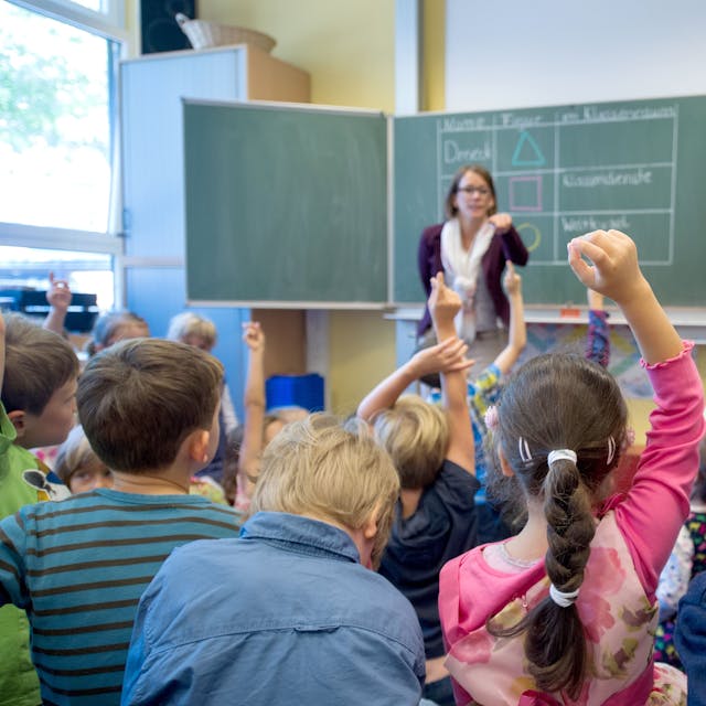 Erstklässler der 1A melden sich am 20.08.2014 während ihrer ersten Unterrichtsstunde in der Henri-Dunant-Schule in Düsseldorf (Nordrhein-Westfalen). Vorne steht ihre Klassenlehrerin Melanie Beaucamp.