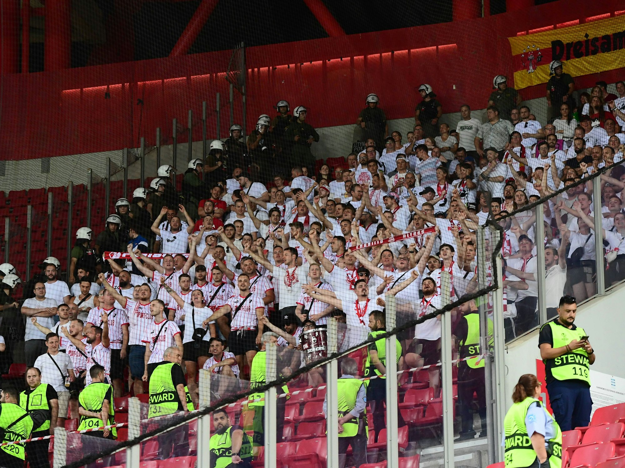 Im Gästeblock in Piräus stehen die Fans des SC Freiburg. Fast alle tragen weiße Shirts.