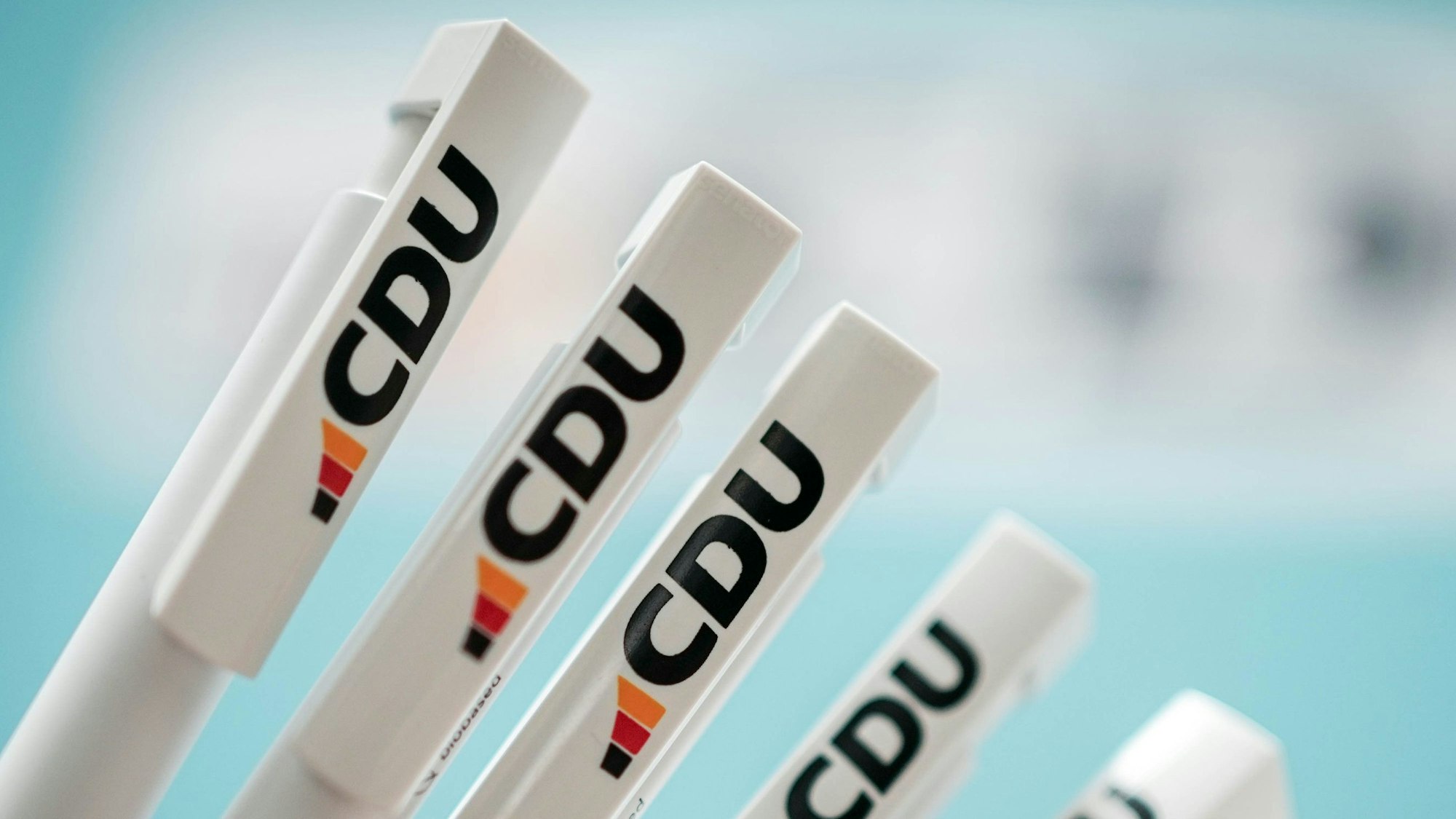 Auf mehreren weißen Kugelschraubern ist das neue Logo der CDU zu sehen. Neben drei Säulen mit den Farben der Deutschland-Flagge gibt es vor allem Kritik für das neue Türkis.