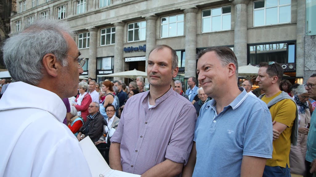 Klaus Schulze Herderling (l) und Peter Bispeling lassen sich am 20. September 2023) beim Gottesdienst in Köln von einem Pfarrer segnen.