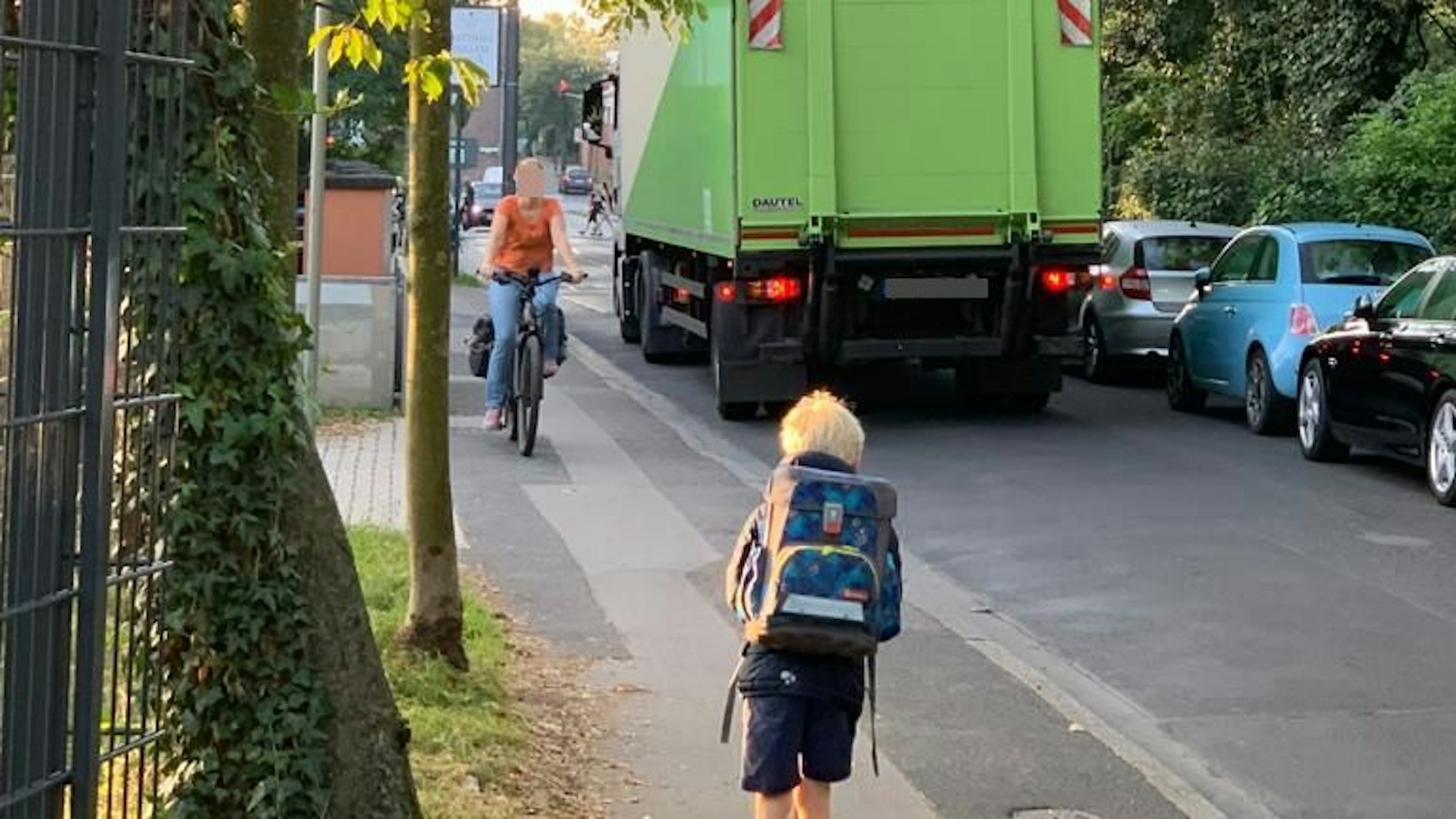 Ein Kind kommt einem Fahrradfahrer auf dem Gehweg entgegen