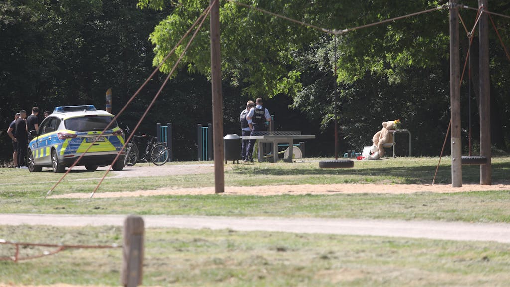 Ein Streifenwagen steht auf einem Spielplatz, auf dem sich auch mehrere Einsatzkräfte der Polizei befinden.&nbsp;