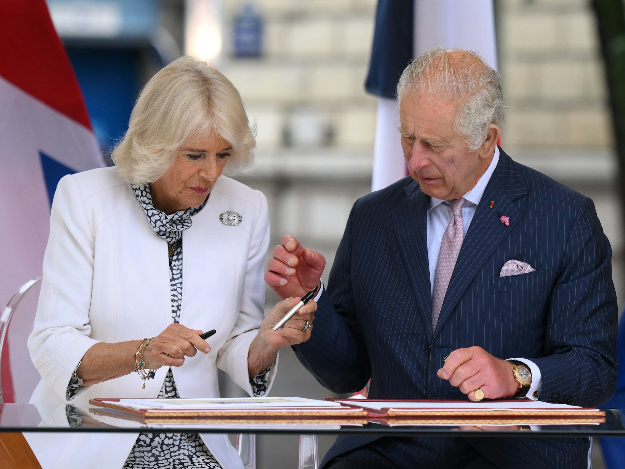 Königin Camilla (l-r) und König Charles III. von Großbritannien signieren ein Buch nach dem Besuch des zentralen Pariser Blumenmarktes.