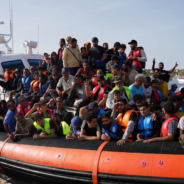 Migranten kommen auf einem Schlauchboot im Hafen von Lampedusa an.