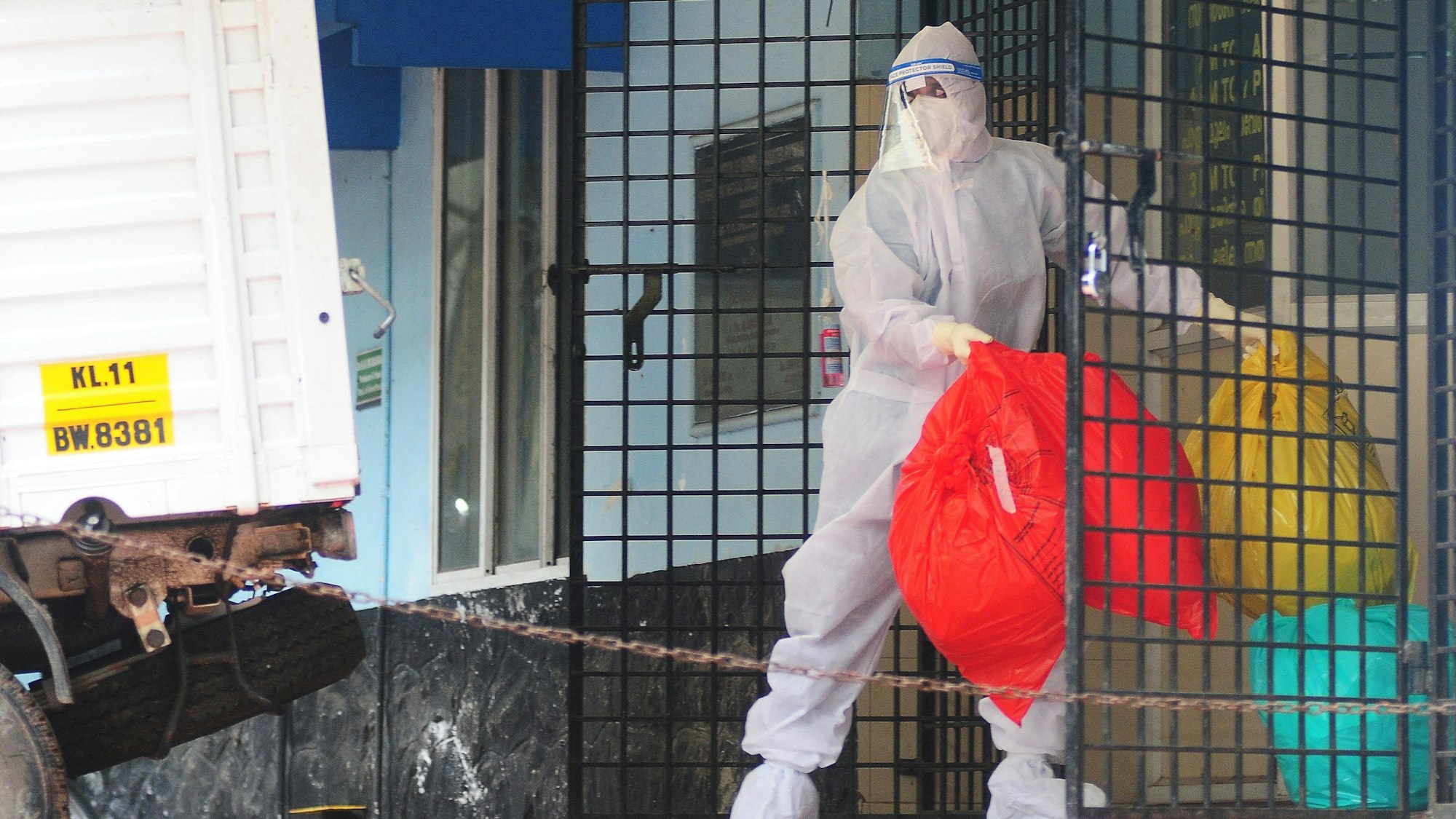 Ein Mitarbeiter des indischen Gesundheitsdienstes trägt mehrere Müllbeutel mit „biologischem Gefahrengut“ aus einem Krankenhaus in der Provinz Kerala, in der das Nipah-Virus ausgebrochen ist.