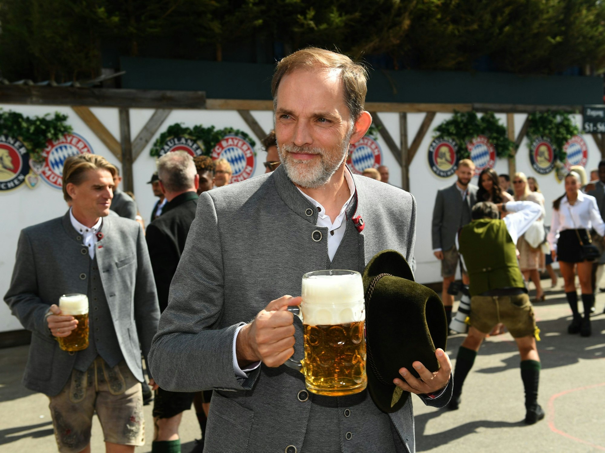 Thomas Tuchel, Trainer des FC Bayern München, steht mit einer Maß Bier vor dem Käferzelt.