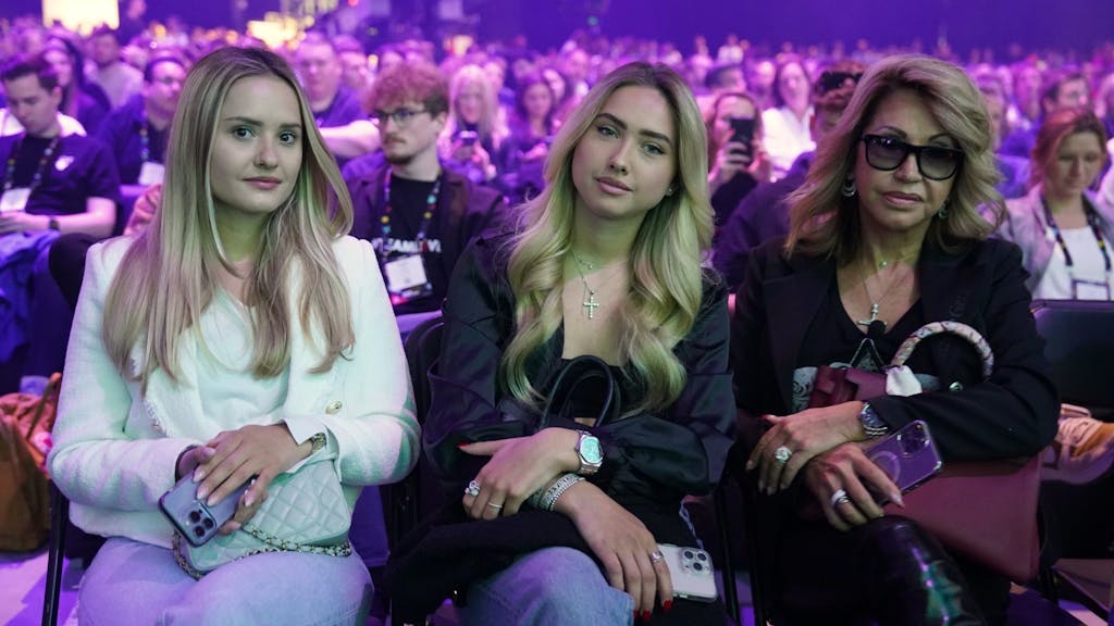 Davina (l.) und Shania Geiss (m.) sitzen neben ihrer Mutter Carmen Geiss (r.) während des Auftritts von Robert Geiss, Unternehmer und TV-Reality-Star, auf der Bühne der Digital-Messe OMR in den Messehallen.&nbsp;
