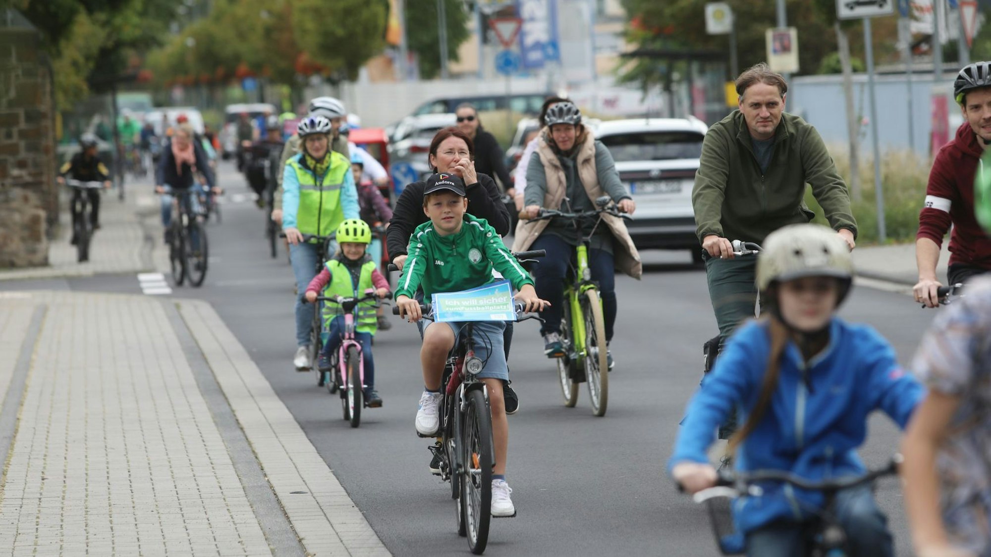 Kinder und Erwachsene fahren bei der Kinder-Fahrraddemo durch Bad Honnef.
