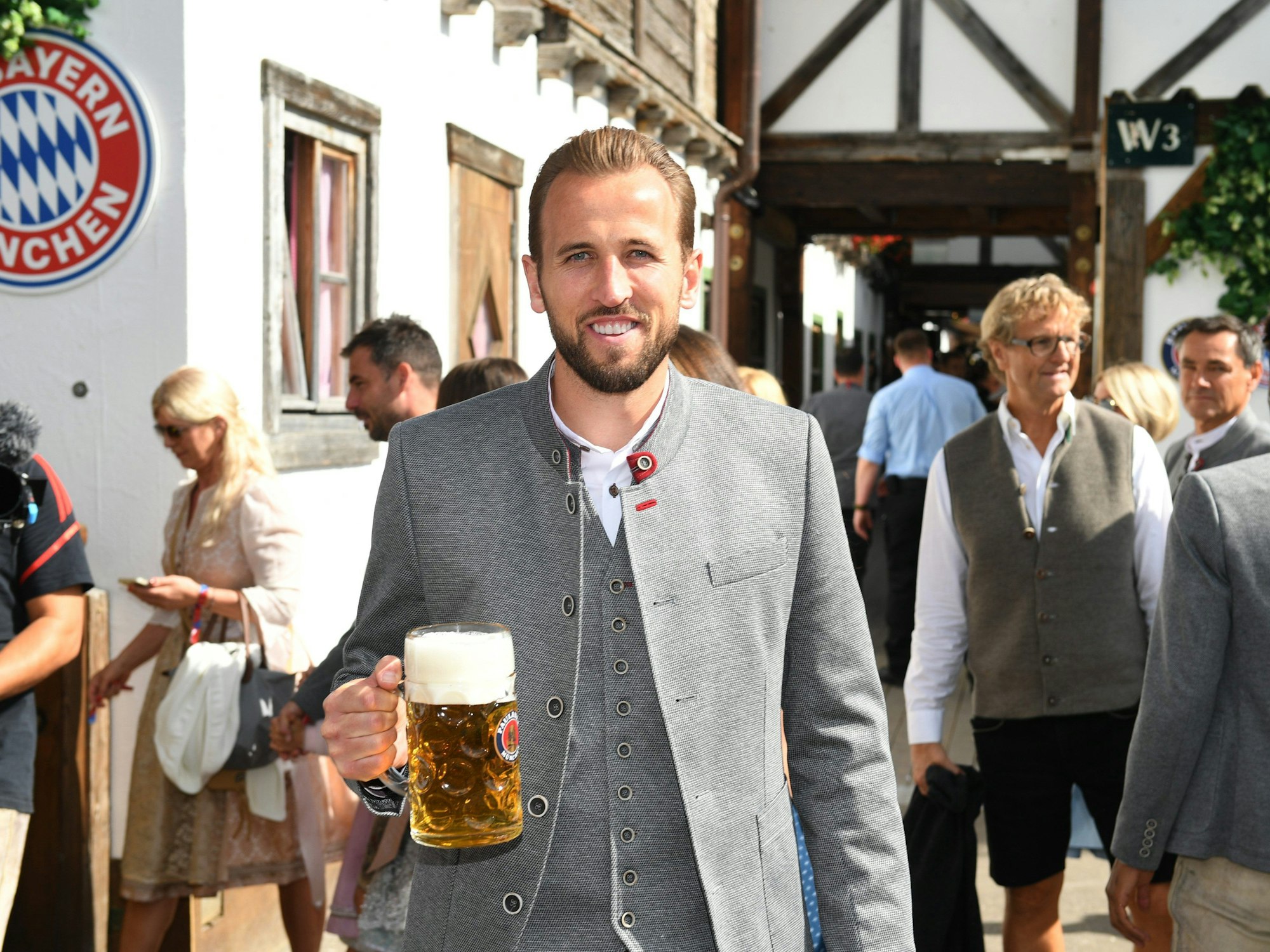 Harry Kane vom FC Bayern München steht mit einer Maß Bier vor dem Käferzelt.