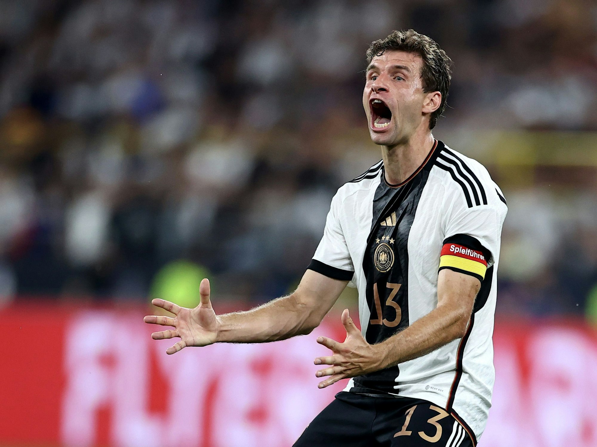 Thomas Müller im Trikot der Nationalmannschaft reißt den Mund weit auf.