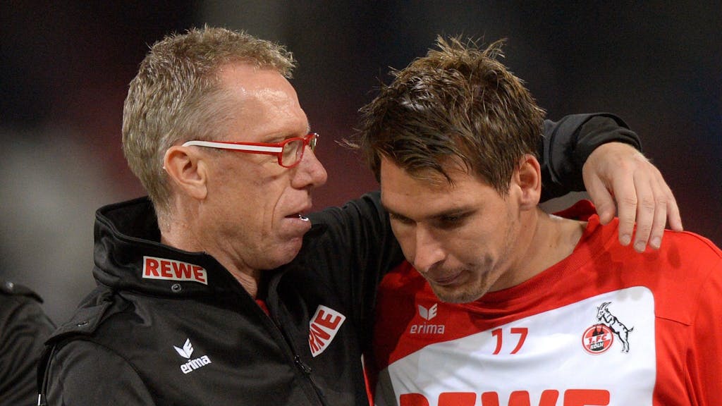 Patrick Helmes und Peter Stöger sprechen nach einem Spiel des 1. FC Köln Arm in Arm.