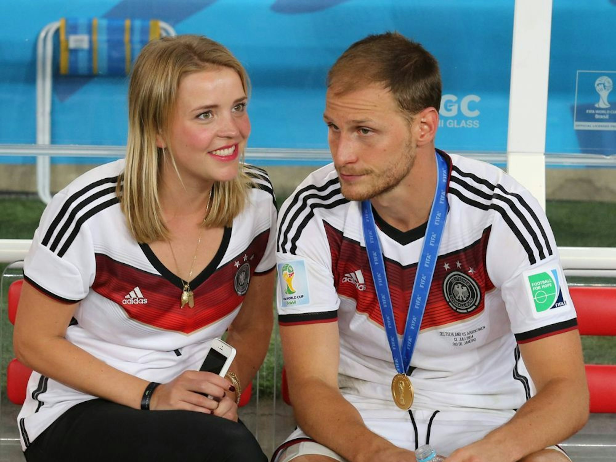 Benedikt Höwedes und Lisa Wesseler nach dem WM-Sieg auf der Ersatzbank. 